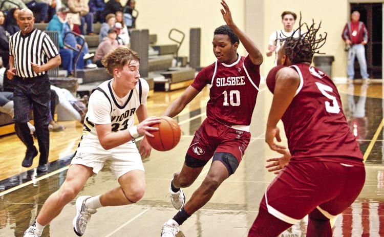 Caden Beavers make a break for the goal between two Tiger defenders.