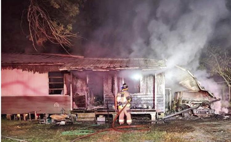 Smoldering remains An Orange County ESD#1 firefighter knocks down hotspots at a home in the 900 block of Pin Oak where two children were rescued by Vidor Police Officers by forcing a window air conditioner inside the home and pulling the children out the window. The cause of the fire was ruled accidental.