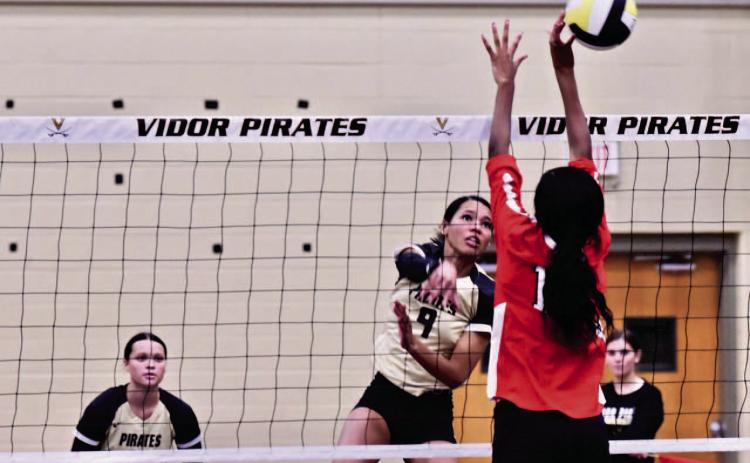 Madison Jones gets an overhand return past a Lady Titan Tuesday in Pirate Gym. Photo by Randall Luker