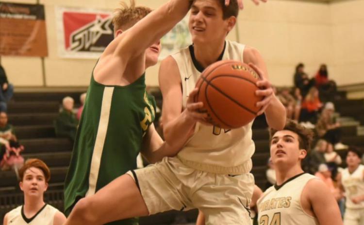 Branson Healy is fouled as he moves in for a shot in Tuesday’s home game versus the LCM Bears. The junior varsity Pirates lost 38-33 in a late change of lead. Photo by Randall Luker