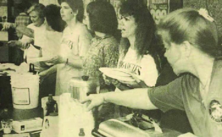 Supporters of the Vidor High School Brigadettes drill team were dishing out pancakes to a hungry public early in front of Woods Supermarket. Late in the morning, they changed to hot dogs, all to raise money for the drill team to go to the Cotton Bowl classic next New Year's Day. Archive Photo