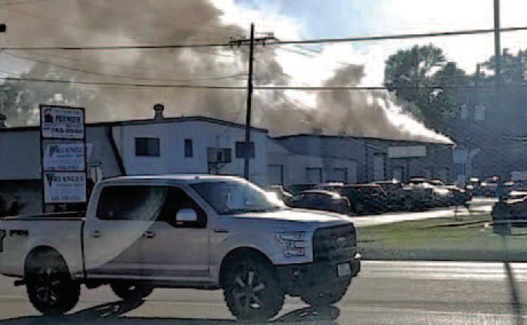 Billowing clouds of smoke pour from the C and R Transmission shop on Garland Street Tuesday after a lithium ion battery caught fire and spread through the building.