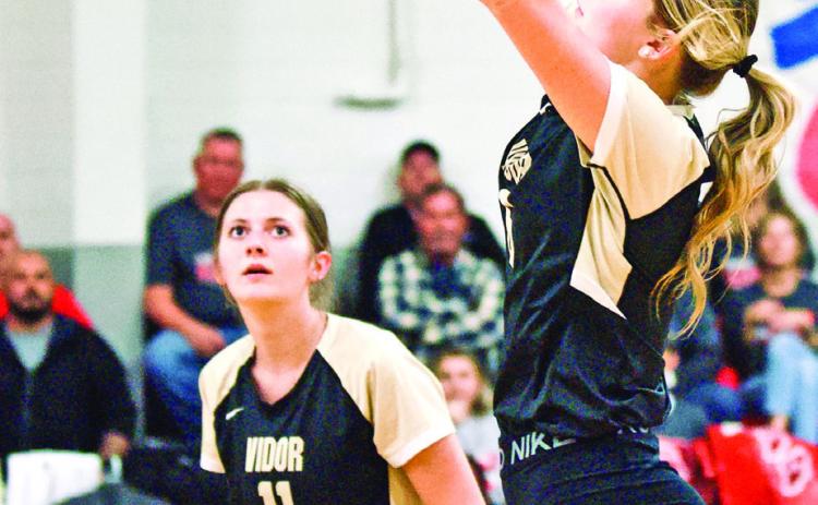Madison Guillot sets the ball as Madison Powell readies for the return in Tuesday ’s bi-district playoff game in Anahuac.