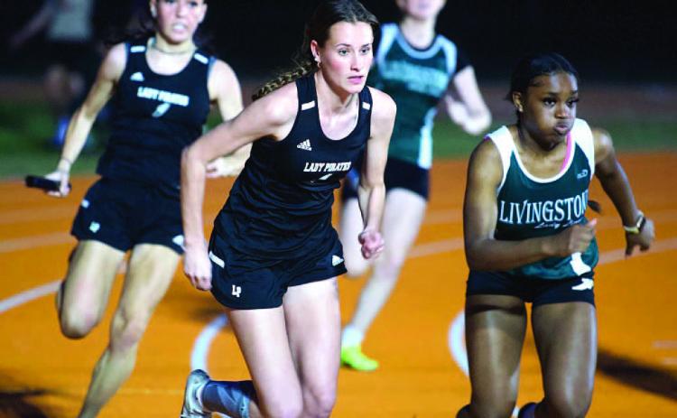 Jaden Lee, front, and Naomi Collier, rear, prepare to handoff in the 4X100 relay event. Photo by Randall Luker