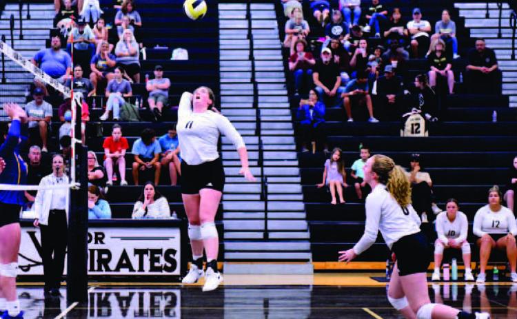 Rylee Sherman takes to the air for a return as Natalie Morrison runs toward the net. Photos by Randall Luker