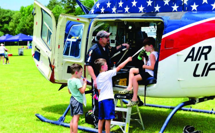The 27th Annual Cops N Kids Picnic is set for June 9 with local first responders showcasing their tools of the trade and offering up close looks at their equipment in a personal and friendly environment. The annual event also offers lunch, rides, games, all free. In this photo from the 2022 event, children view a medical rescue helicopter and talk with the pilot. Photo by Randall Luker