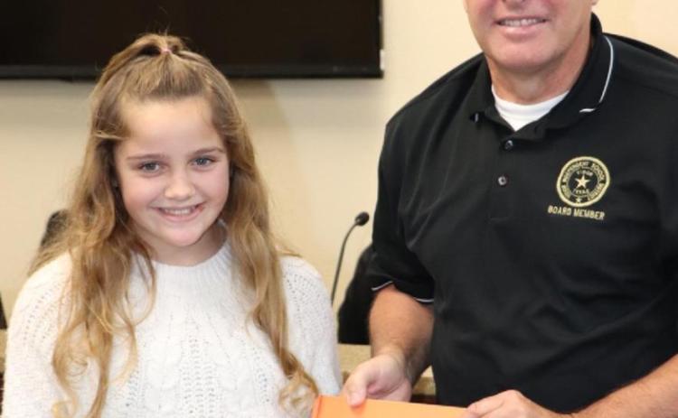 Presenting a book to the Oak Forest library in honor of Mr. David Camp was Jasmyn Smith.