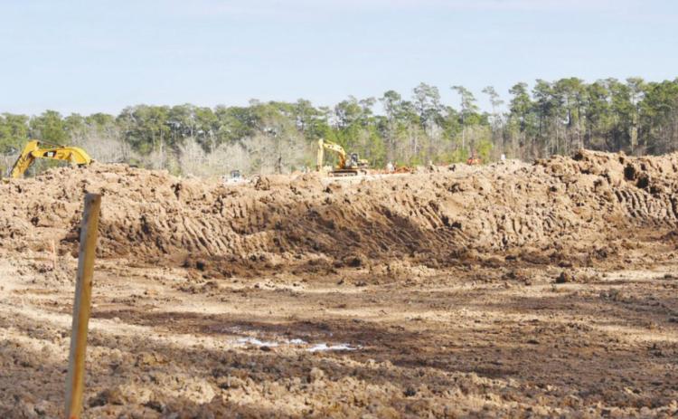 With trackhoes that dug it in the background, this exavation on the northwest corner of the campus was a prerequisite for rebuilding on the Oak Forest Elementary campus. When completed, the detention ponds will capture water runoff before it flows to neighboring properties. As an added bonus, Science classes may also use it as an outdoor lab and observation area.