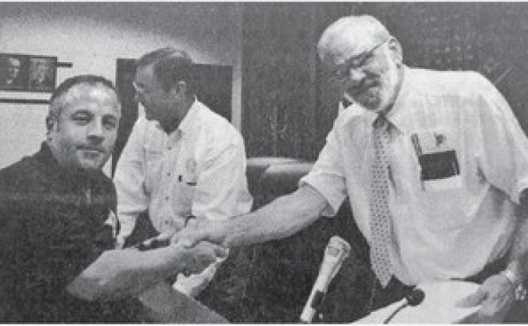 Orange County Judge Carl Thibodeaux, right, and the Orange County Sheriff’s Office Employee Association negotiator Lt. Tom Ray, left, had smiles on their faces as they shook hands after the Commissioners Court tentatively agreed to the union’s contract offer on Monday.