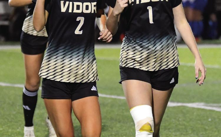 Taylor and Jordin Bull throw their V’s up as they come off the field after pre-game warmups.